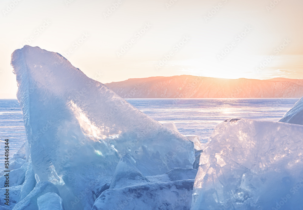 Winter landscape with ice hummocks glittering in the sun and mountains of Lake Baikal in Siberia at 