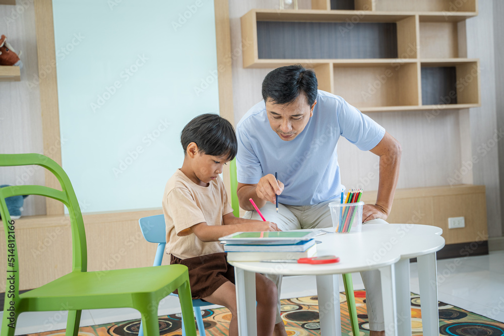 Father teaching children homework in living room.