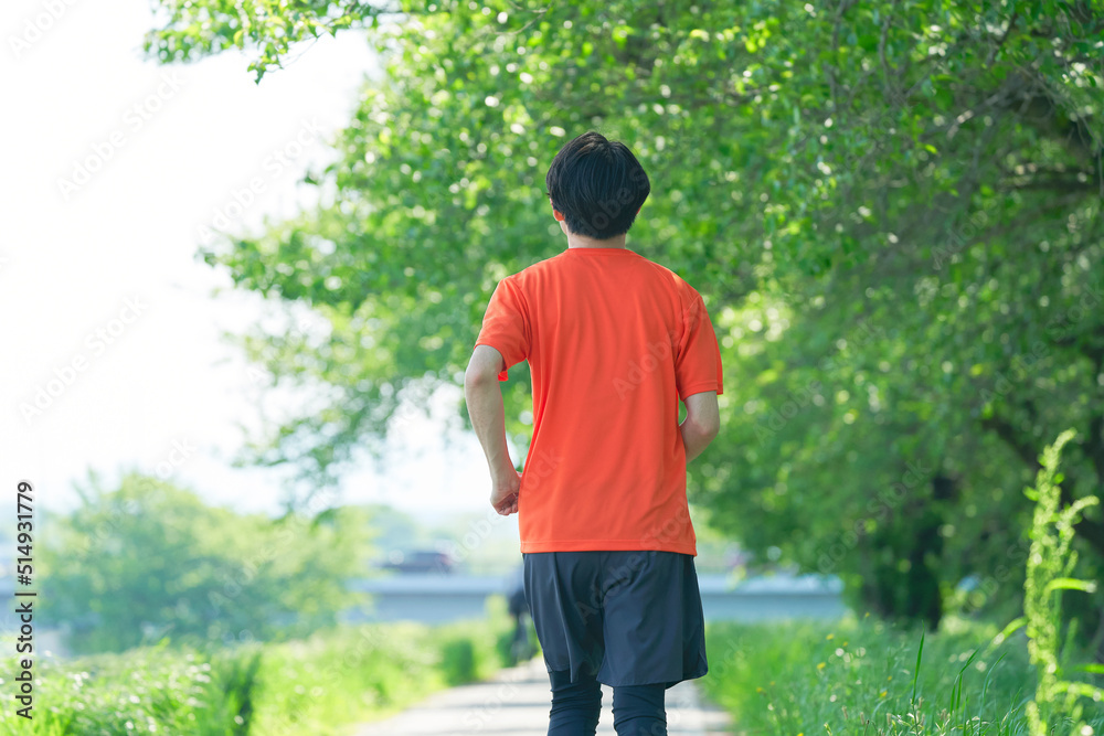 屋外でジョギングする男性の後ろ姿