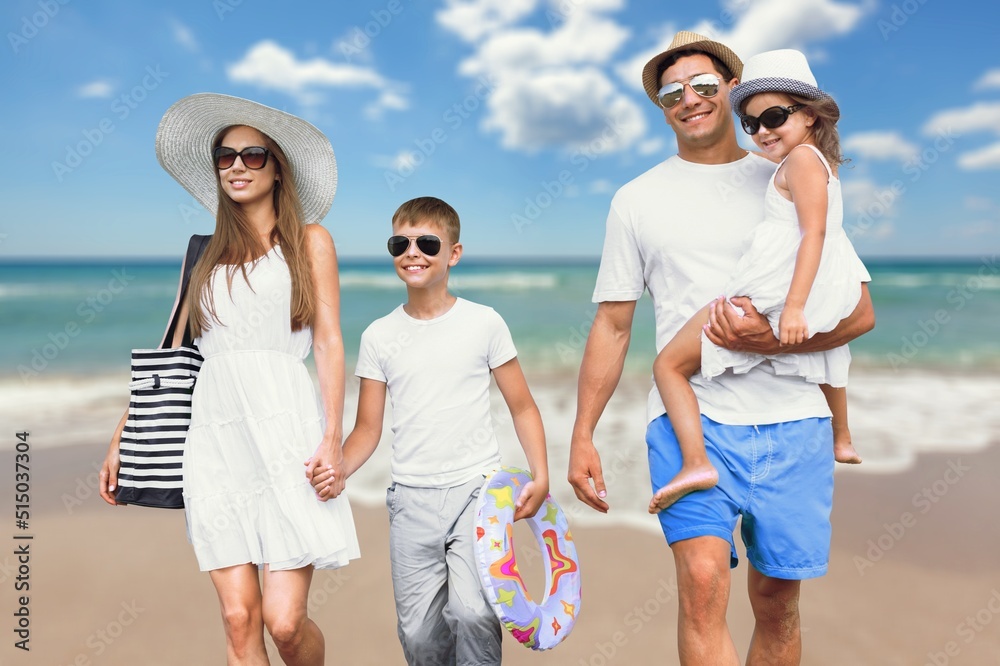 Happy young family walking on the beach