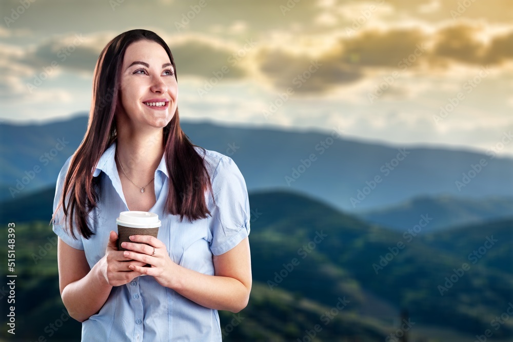 一位美丽的年轻女子喝着咖啡，在自然景观中放松的肖像图像