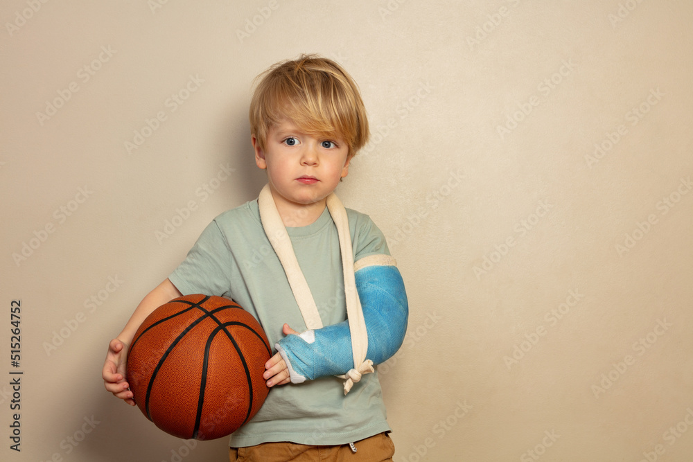 Sad crying little blond boy with basketball ball