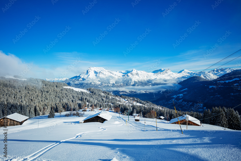 Covered by snow houses after snowfall and off-piste ski tracks