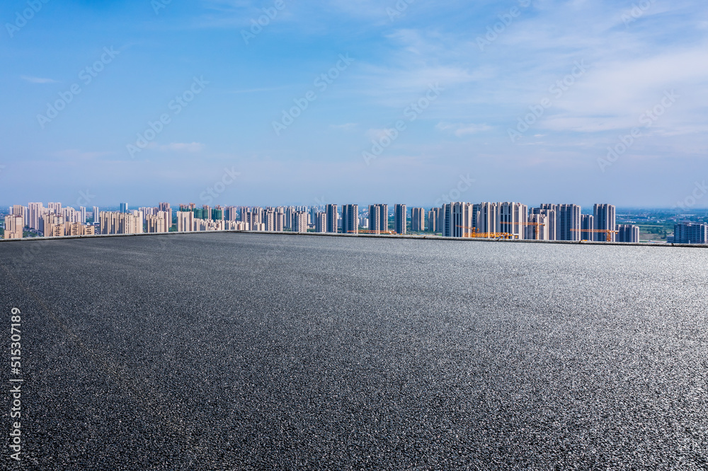 空旷的柏油路和现代城市天际线，建筑景观。高角度视野。