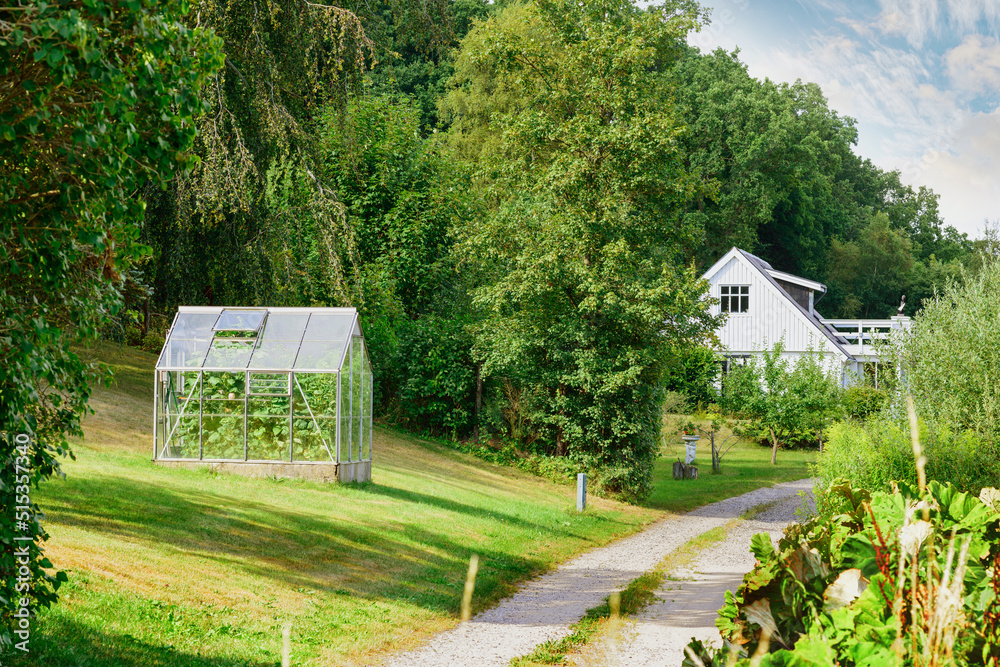 Old Barnhouse. An entrance to a beautiful greenhouse with an abundant garden on the lawn. A countrys