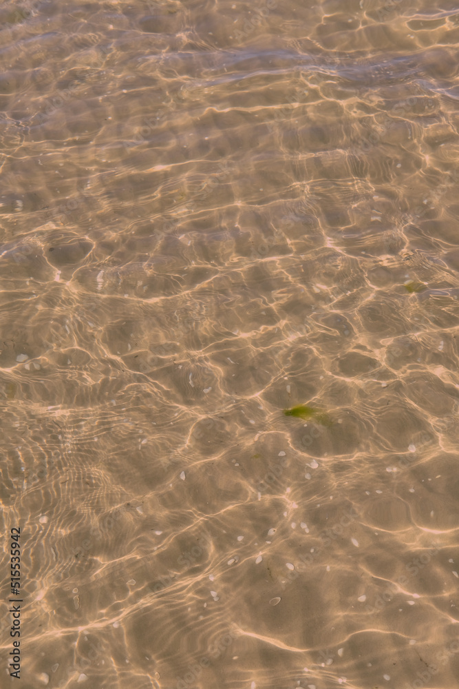 Clear beach water on a summer day with copy space. Above view of calm low tide sea ripples during sp