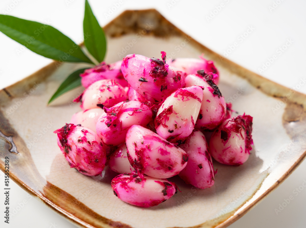 Pickled shiso garlic served on a plate set against a white background.