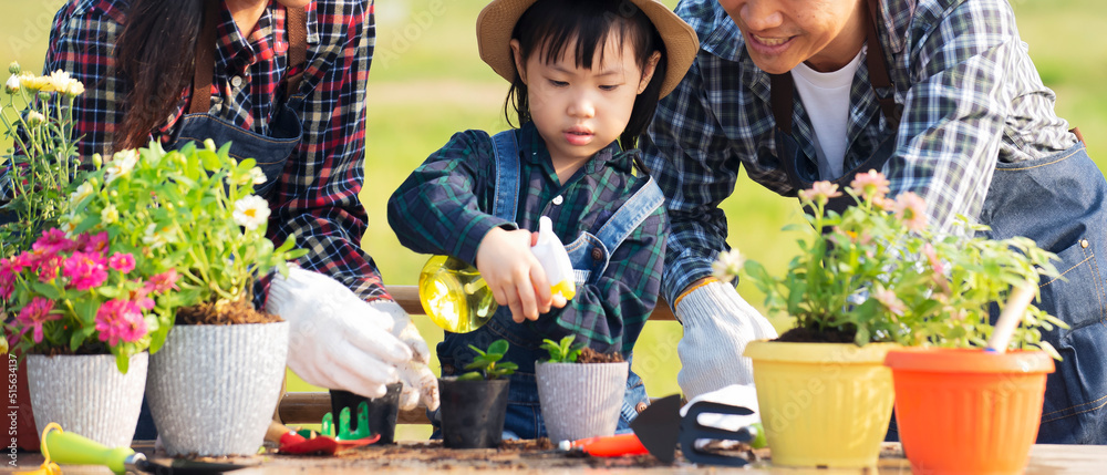 剪亚洲小女孩在户外花园里盆栽