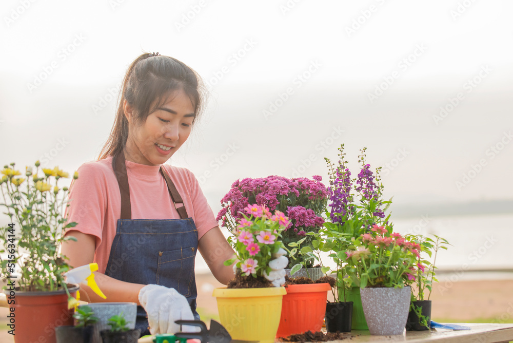 戴着手套的亚洲妇女在户外种花的肖像