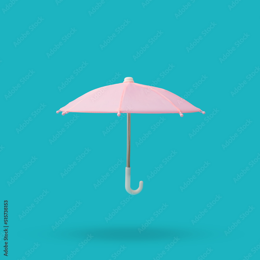 Pink umbrella with metal and plastic handle on a blue background.