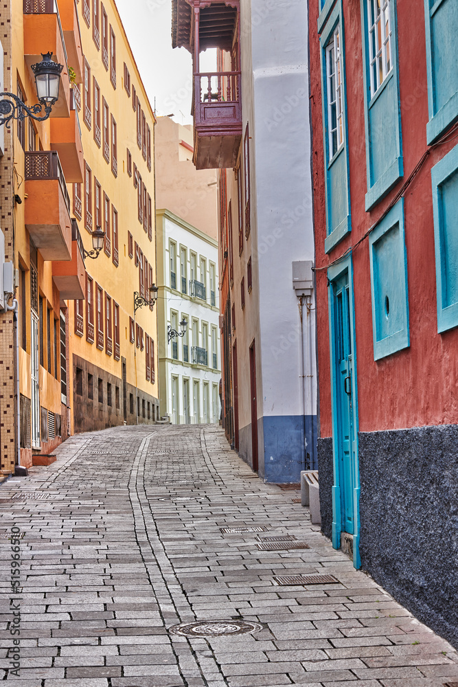 Narrow cobbled street or alley between colorful buildings in Santa Cruz, de La Palma. Bright and cla