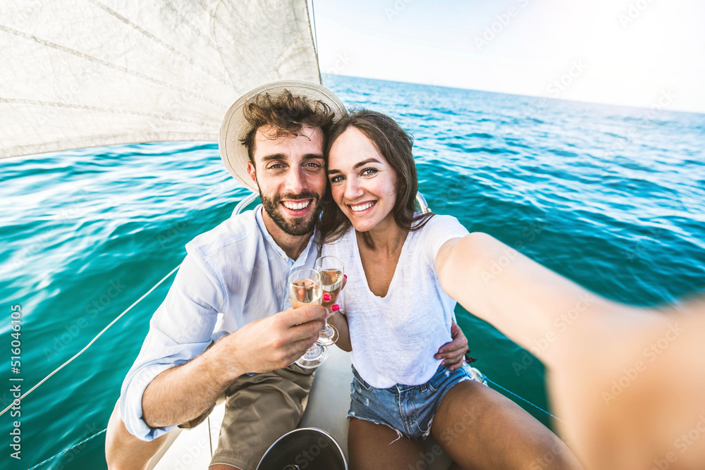 幸福的情侣在海洋中享受帆船旅行体验-男朋友和女朋友ta