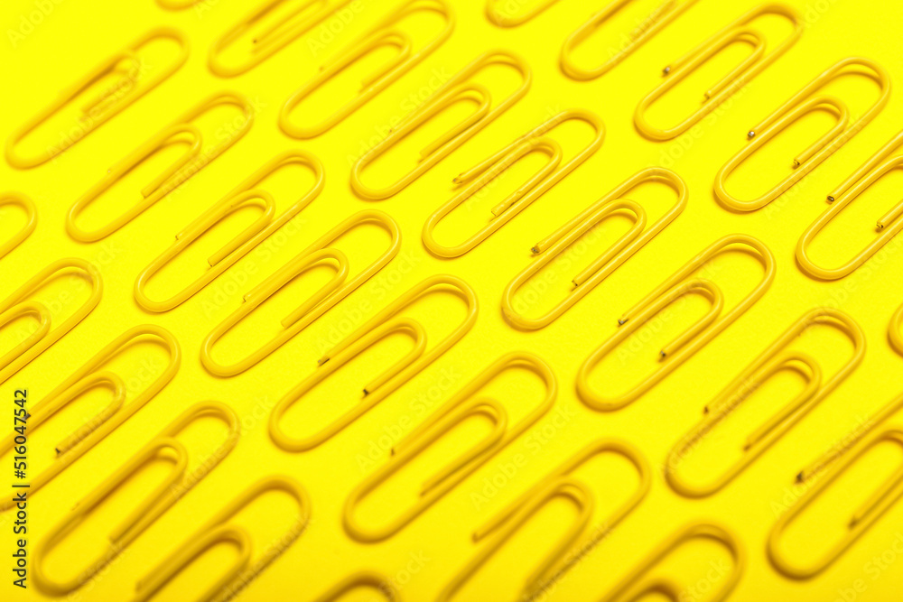 Yellow paper clips on color background