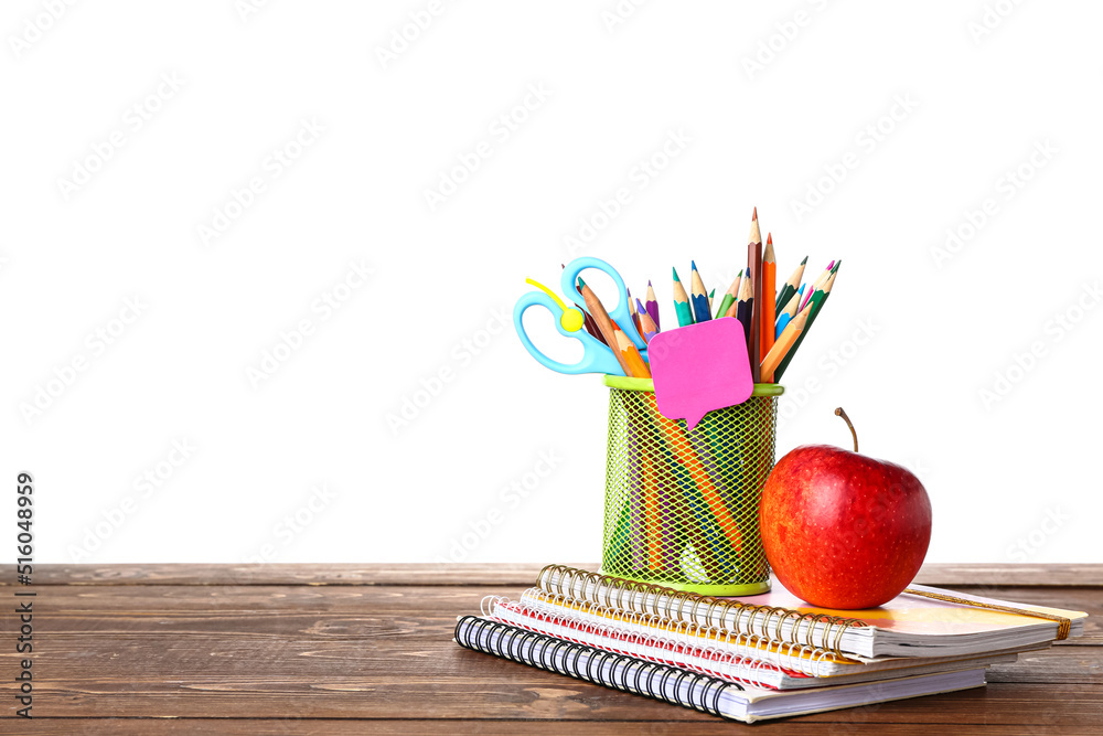 School stationery with apple on wooden table against white background