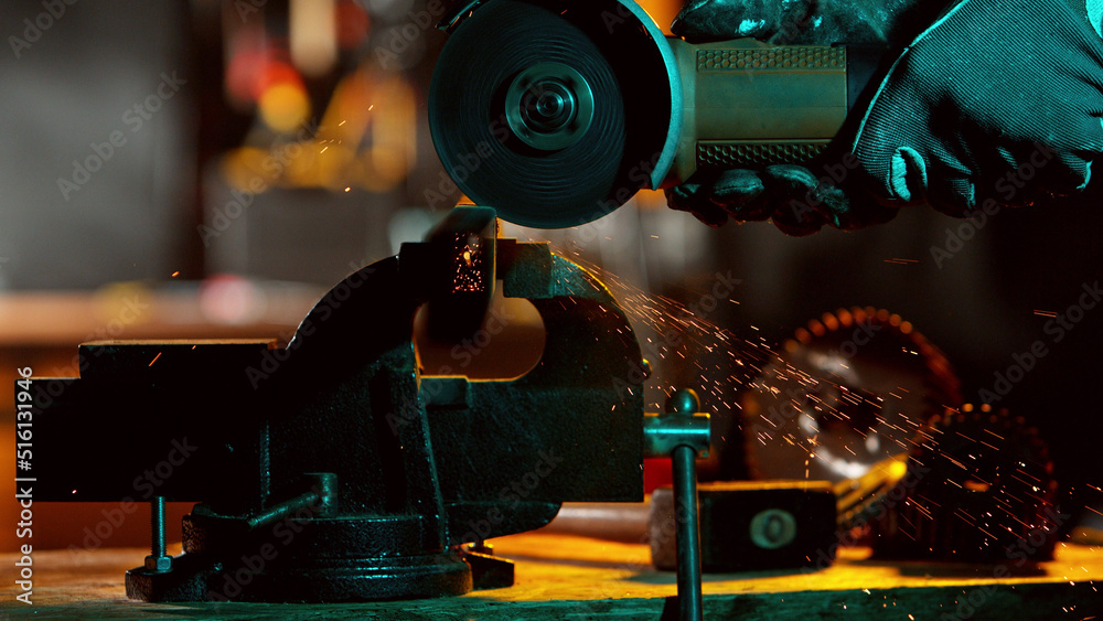 Detail of industry worker cutting steel pipe with flex saw