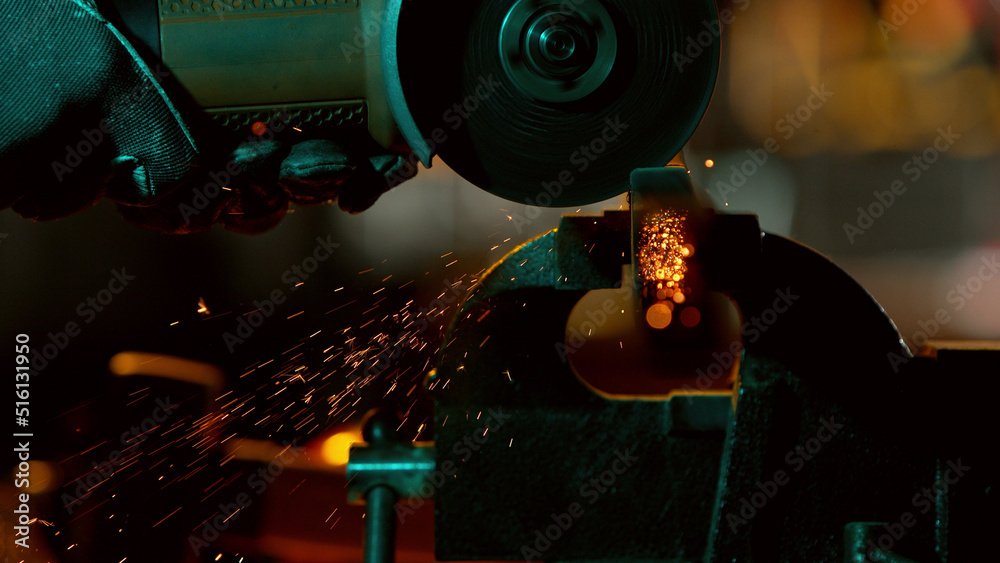 Detail of industry worker cutting steel pipe with flex saw