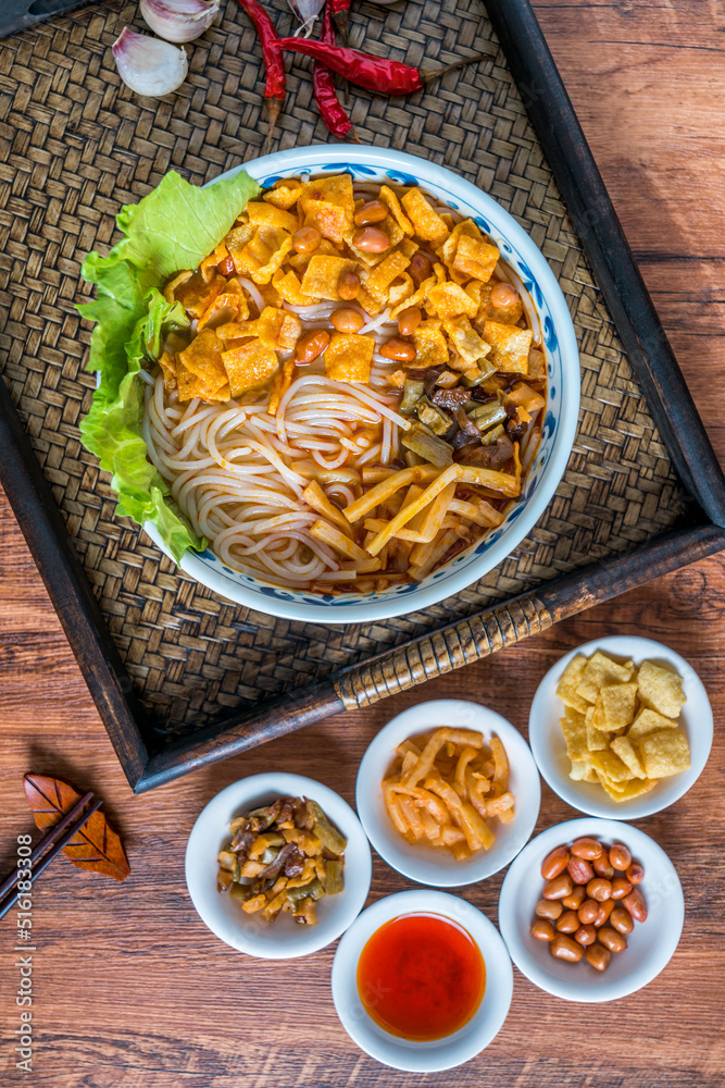 A bowl of Guangxi Liuzhou gourmet snail noodles on a wooden table