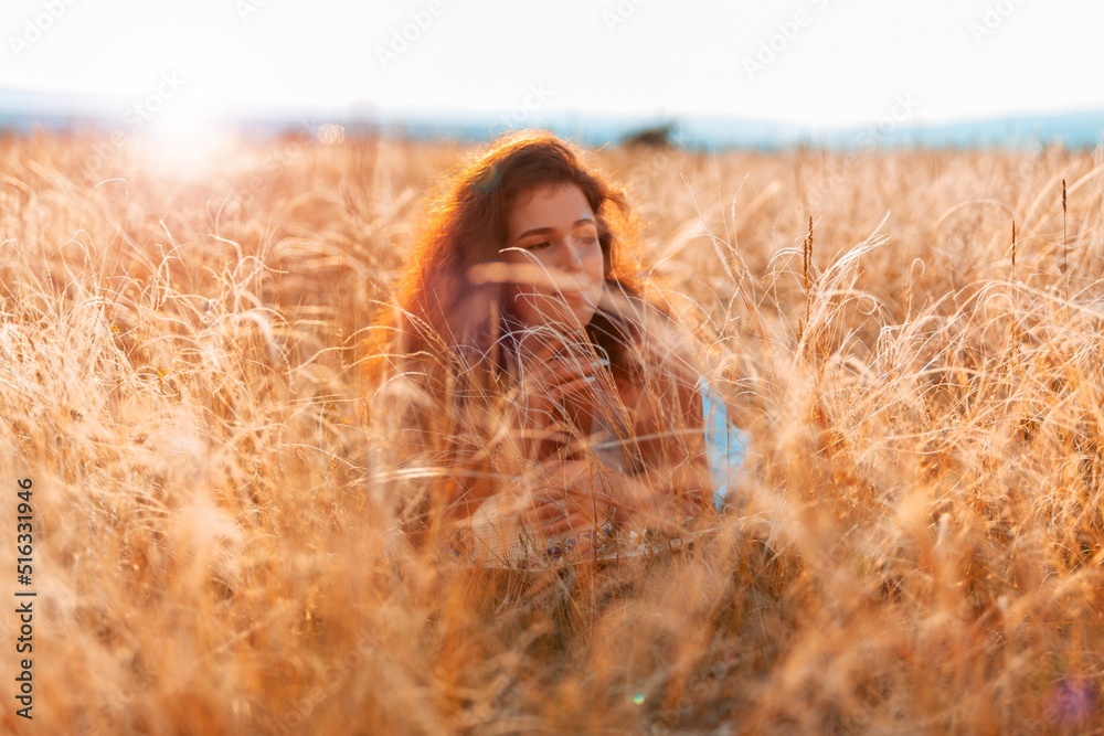 美丽微笑的年轻女孩在田野里放松