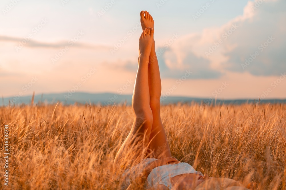 Beautiful  Legs of young woman with hat in field