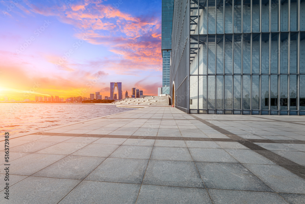 Empty floor and modern city skyline with buildings at sunset