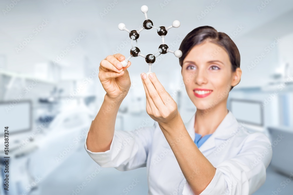 A young scientist looking at a molecular structure model.