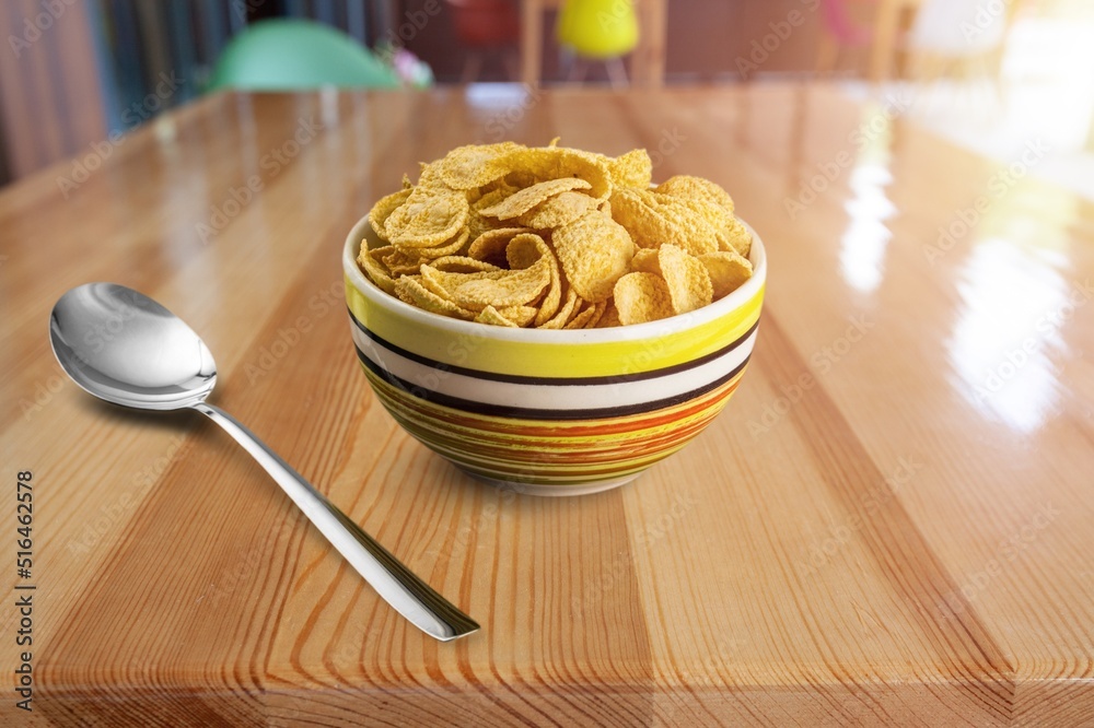 Corn flakes with milk in bowl on the desk