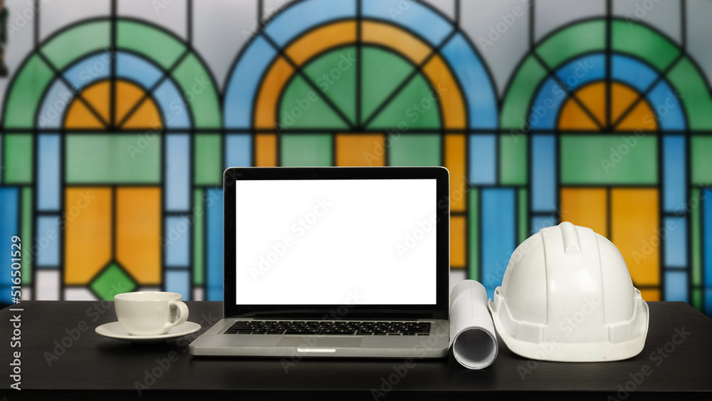 Front view of laptop computer and office construction on table in office blurred background.Architec