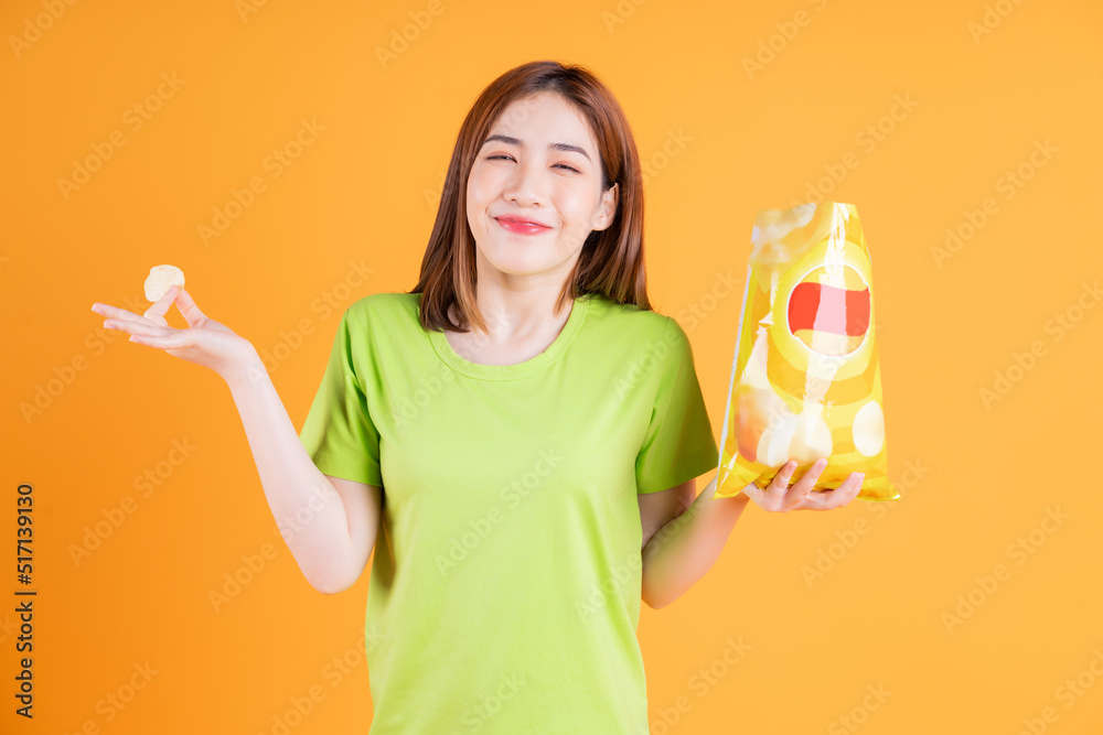 Photo of young Asian girl eating snack on background