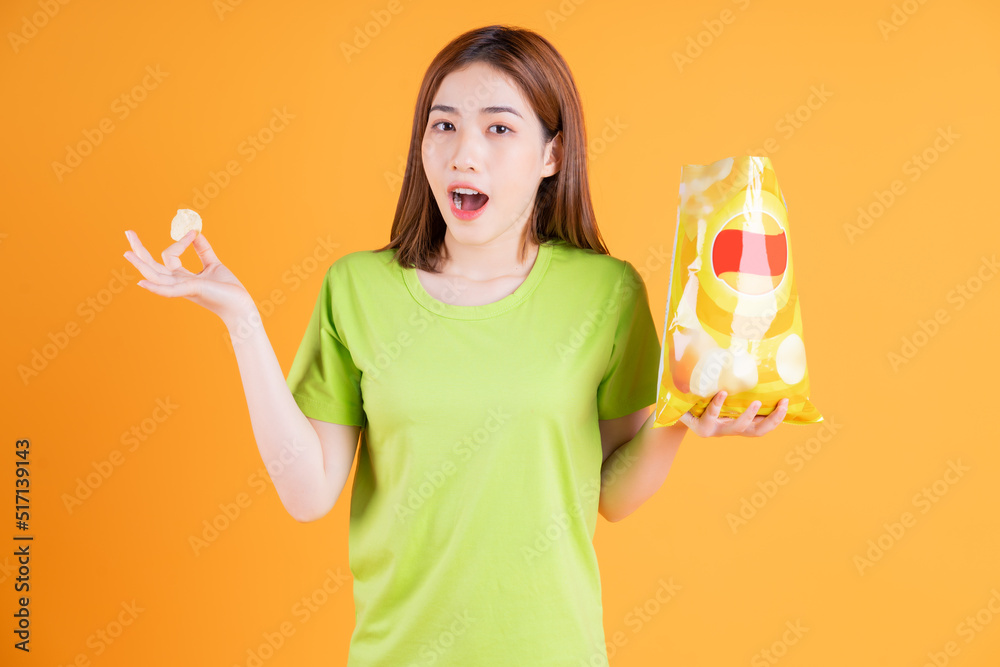 Photo of young Asian girl eating snack on background