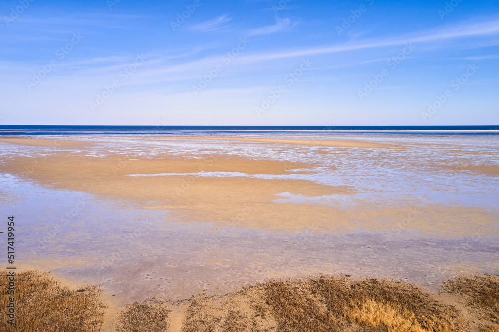 A landscape of the beach shore and blue sky background with copy space on a summer day. The sea or o