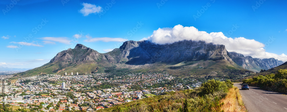 A mountain road overlooking the city with a cloudy blue sky. Panoramic landscape of green mountains 