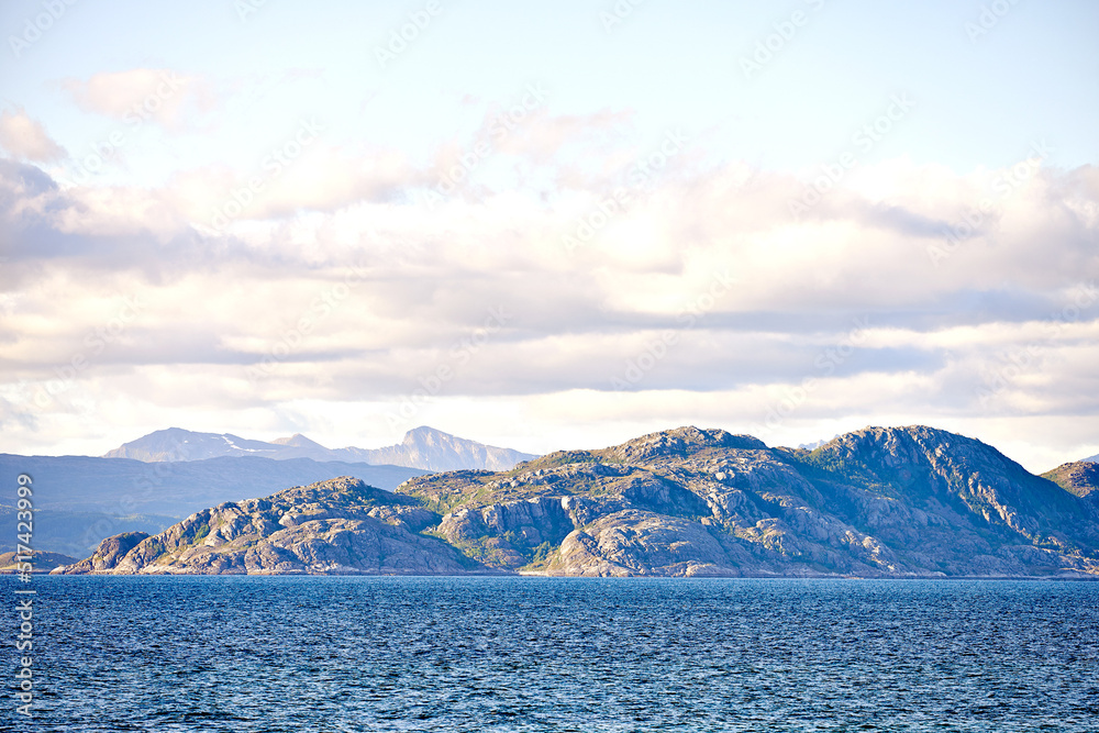 挪威的海洋、山脉、岩石和巨石的美景。潮汐般的海浪，湛蓝的天空。