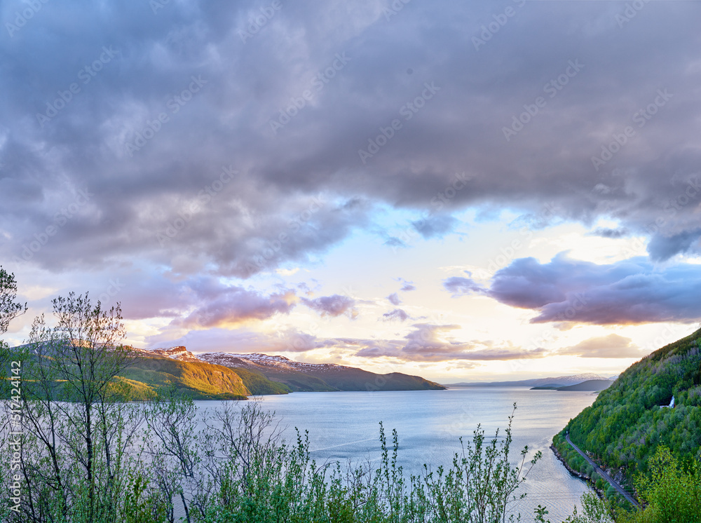 Scenic view of a lake, ocean or sea with cloudy sky at sunset and copy space.Uncultivated trees, bus