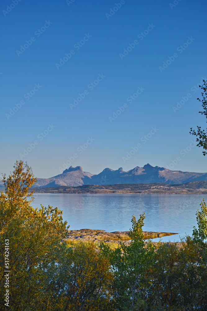 A sea landscape near a mountain with a blue sky background and copy space. Vibrant outdoors by the o