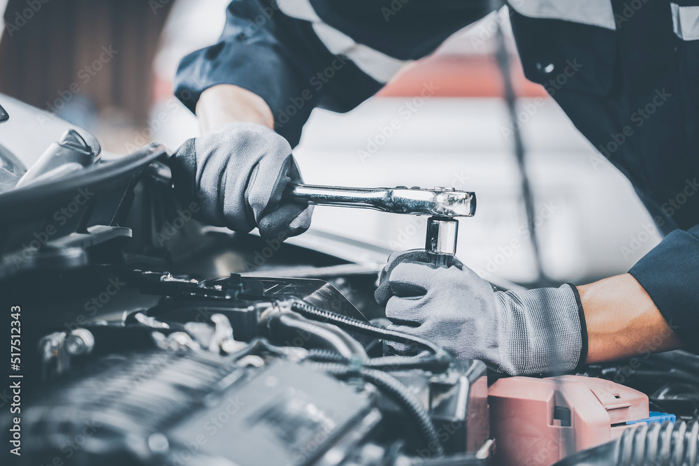 Mechanic works on the engine of the car in the garage. Repair se