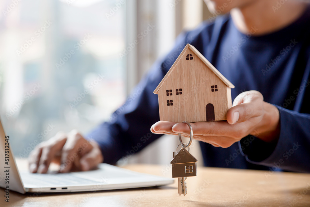 Men holding house model in hand and calculating financial chart for investment to buying property.	
