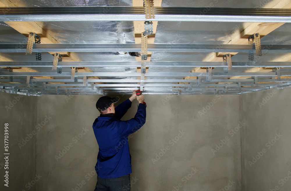 Man assembles profile metal frame for plasterboard