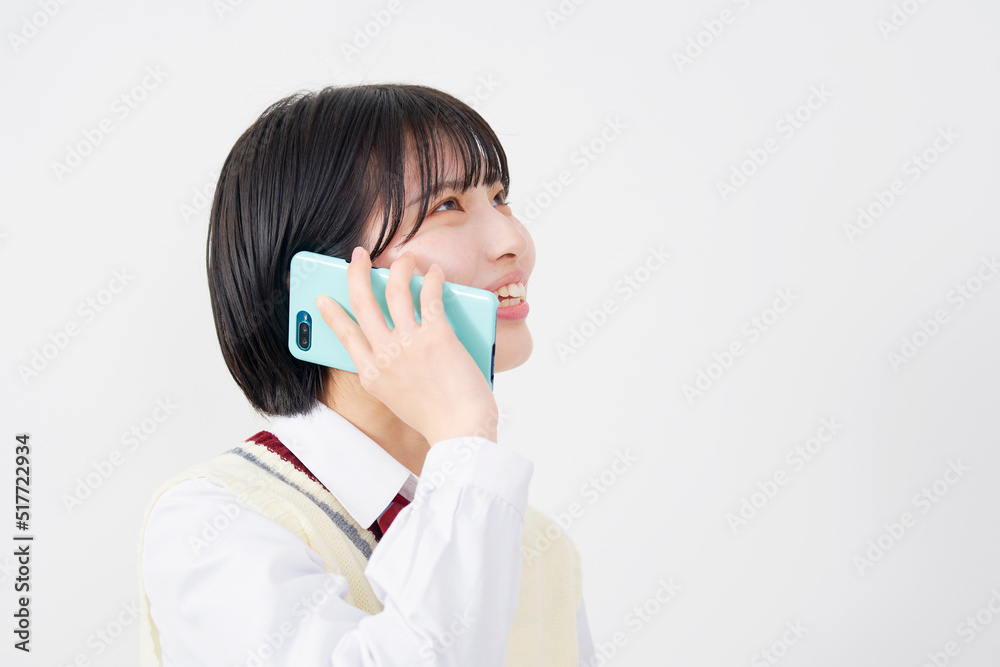 スマホで電話する女子高生　白背景