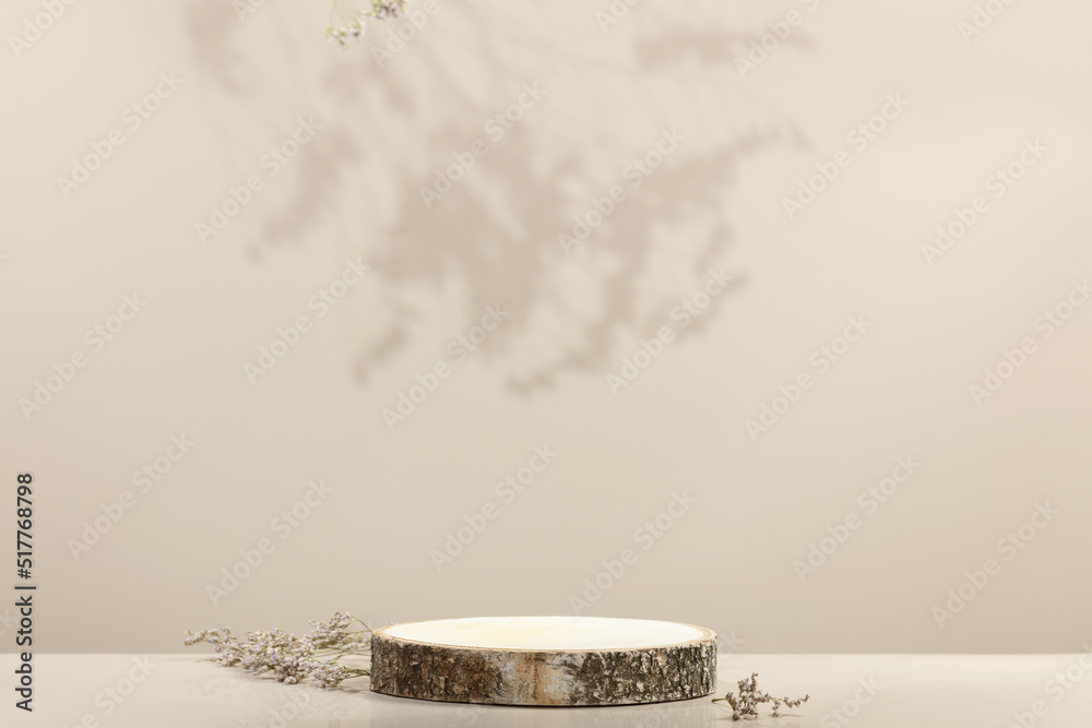 Wood slice podium and dry flowers on beige background for cosmetic product mockup