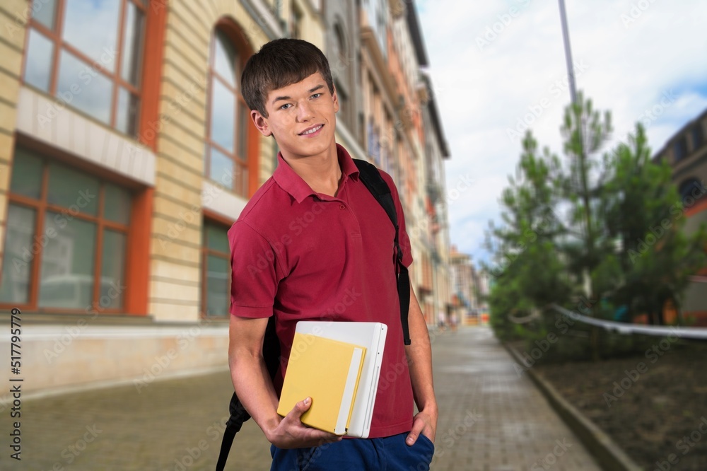 快乐少年大学或学校男孩的画像，背包里装着书，