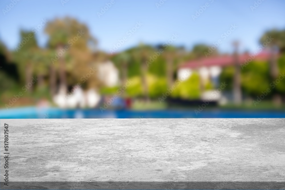 Empty table top and blurred swimming pool in tropical resort in summer for display or montage your p