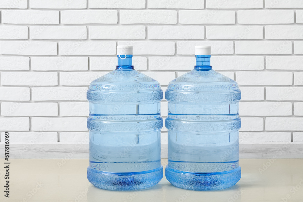 Bottles of clean water on floor near light brick wall