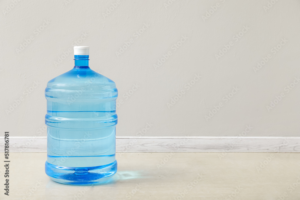 Bottle of clean water on floor near light wall