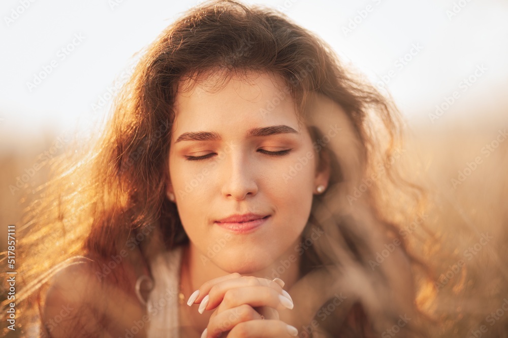 Pretty smiling young girl relaxing in field