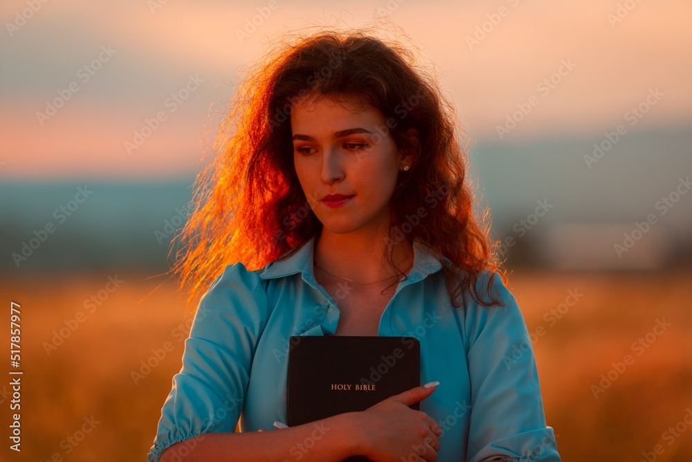 Christian woman holds bible book in her hands.