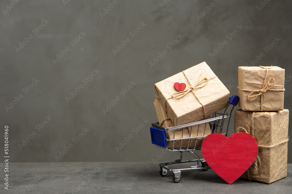 Valentines Day greetings concept. Gift boxes in a shopping cart and red heart shaped card with empt