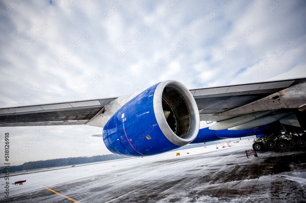 Airplane engine with aircraft wing on runway of airfield