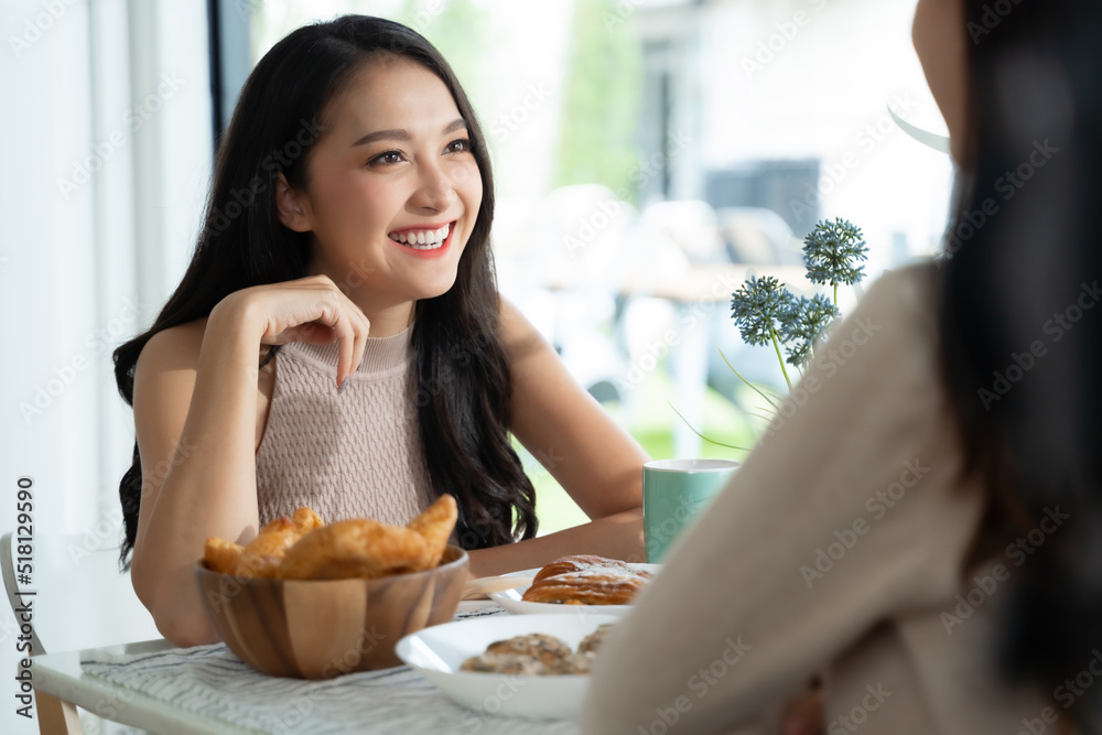 两位年轻的亚洲女性朋友在咖啡店聊天