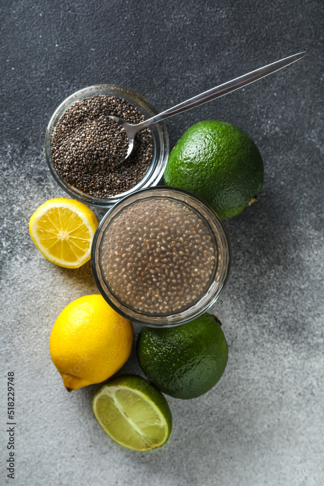 Glass of water with chia seeds and citrus fruits on black and white background