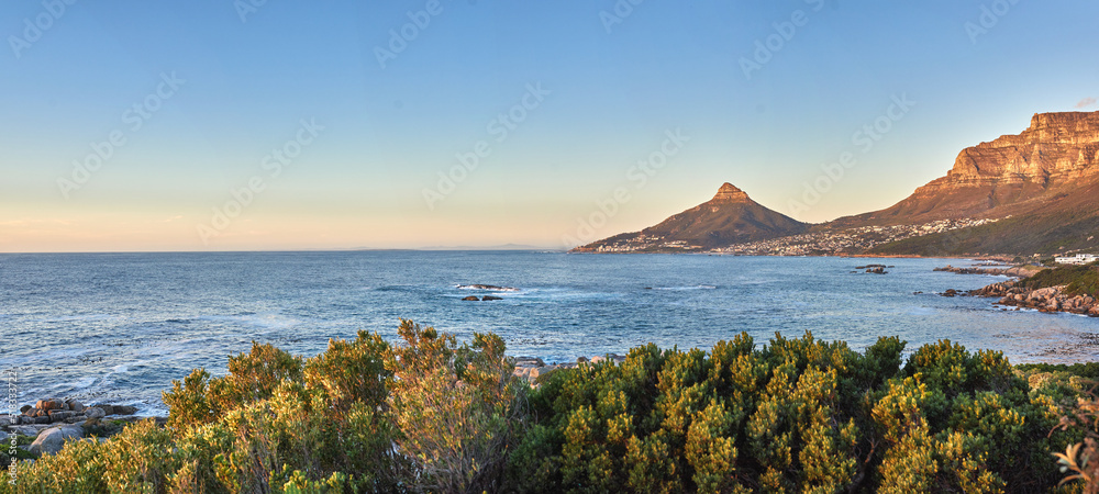 令人惊叹的蓝色海洋，日出天空背景和复制空间上有山脉。夏季景观